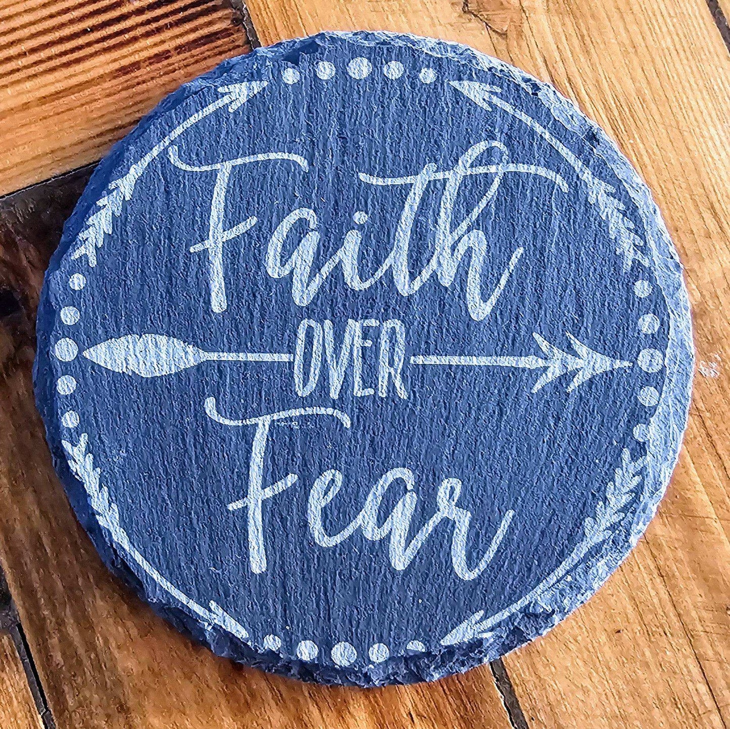 a stone with the words faith over fear painted on it