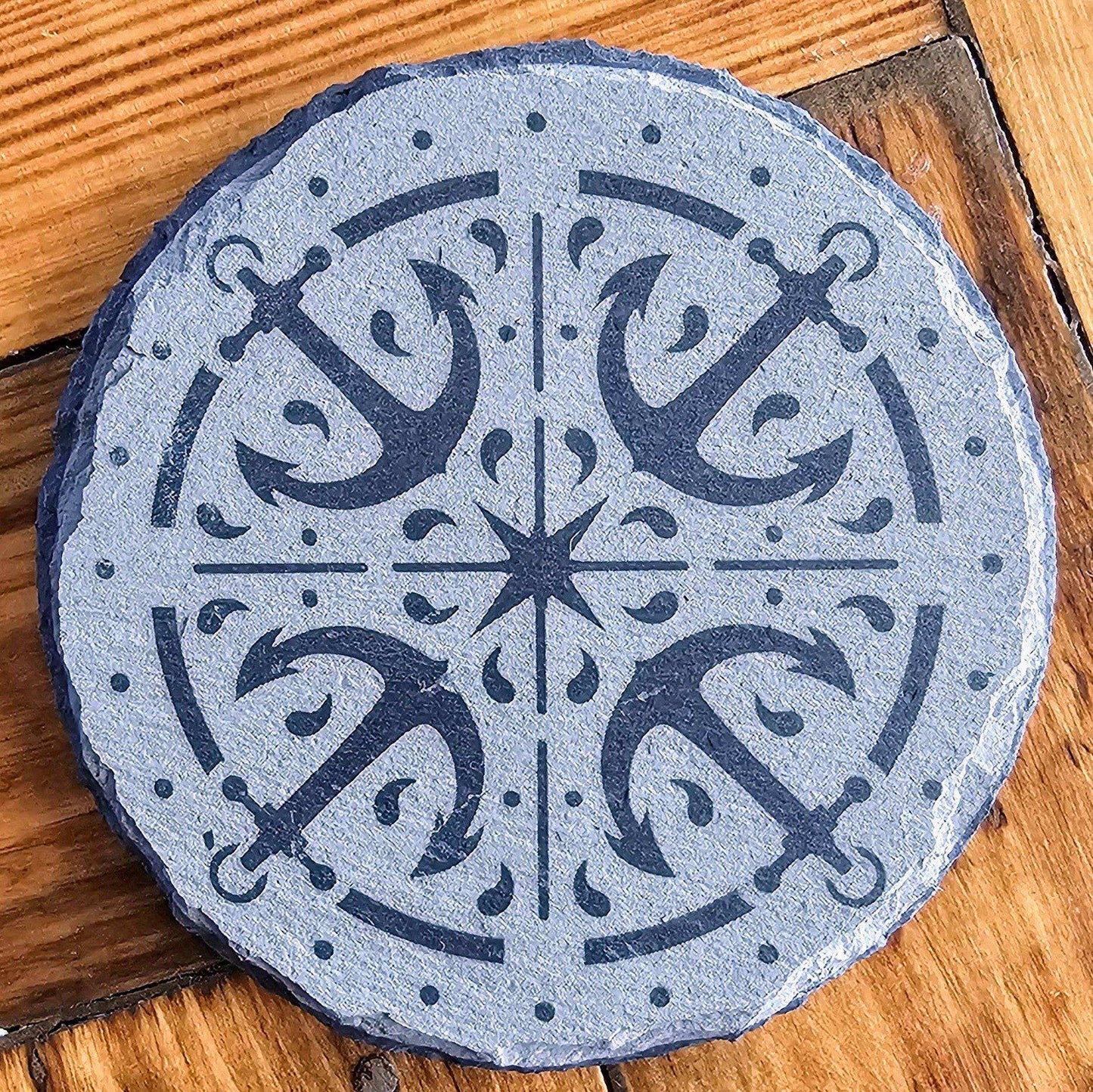 a round stone with a design on it on a wooden floor