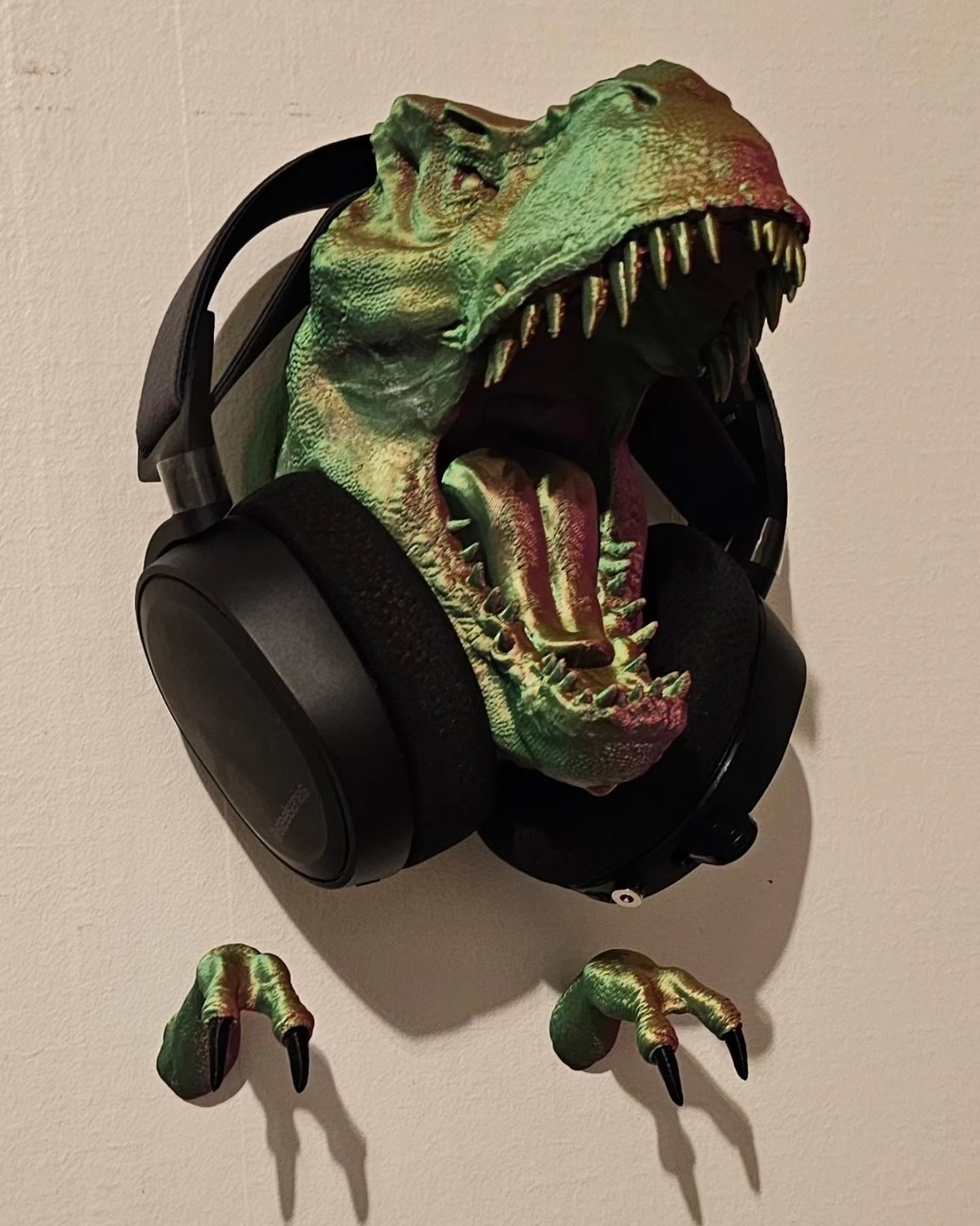 a dinosaur head with headphones hanging on a wall