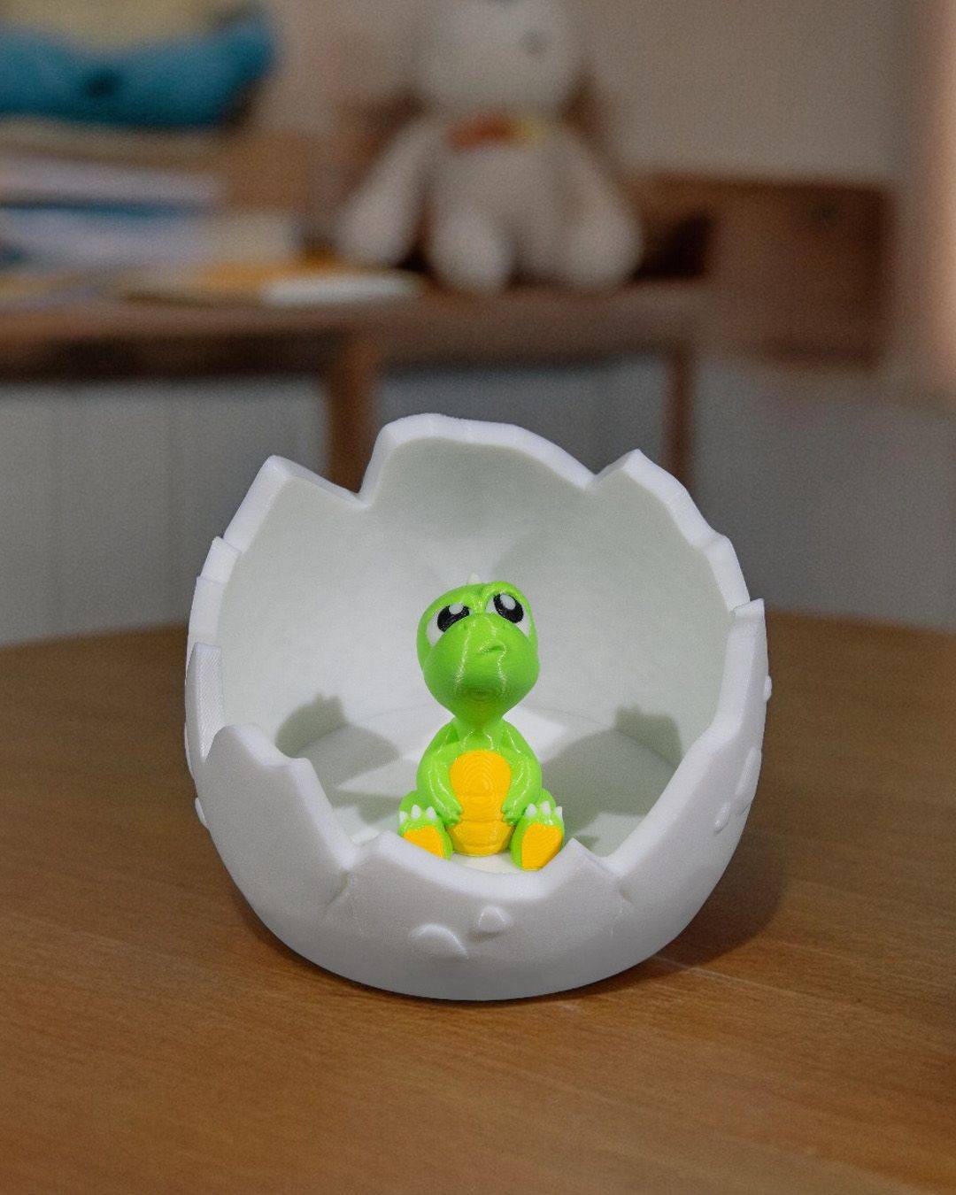 a toy turtle in an egg shell on a table