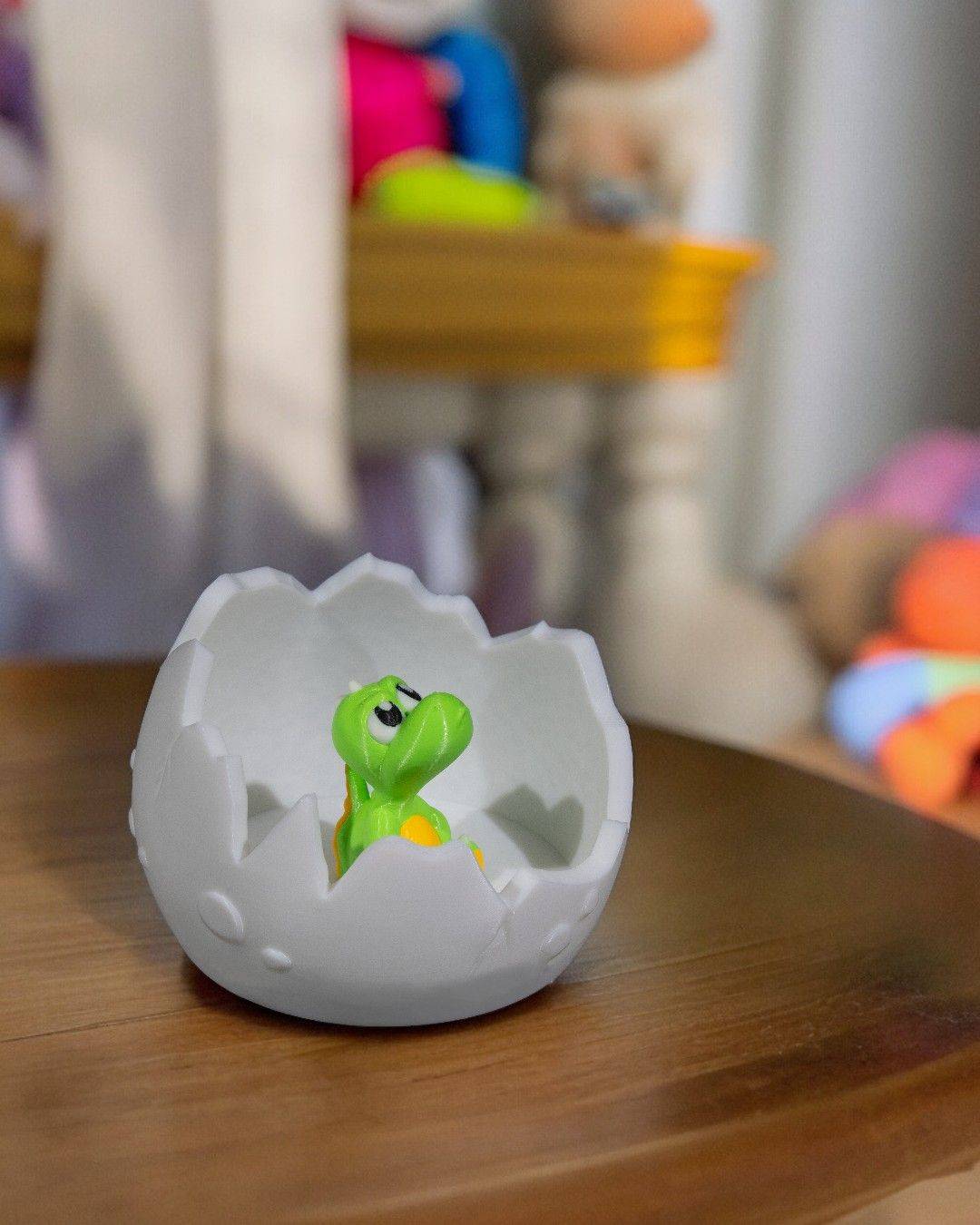 a toy dinosaur in an egg shell on a table