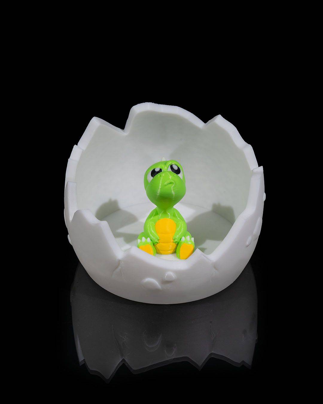 an egg shell with a small toy turtle inside of it